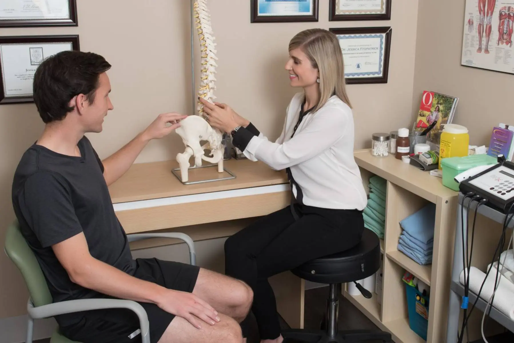 a woman and man sitting in a room with a skeleton